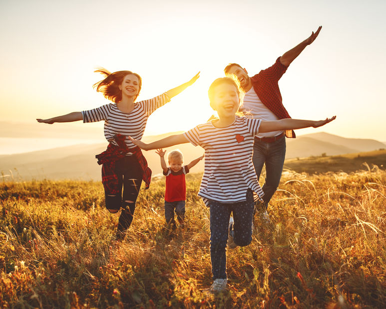 Happy family outdoors at sunset